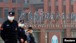 资料照片：2021年2月3日，世界卫生组织团队访问中国湖北省武汉市，安全人员在武汉病毒研究所外值守。（路透社照片）