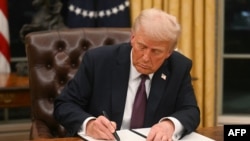 Президент США Дональд Трамп підписує указ в Овальному кабінеті Білого дому у Вашингтоні, 20 січня 2025. Photo by Jim WATSON / POOL / AFP
