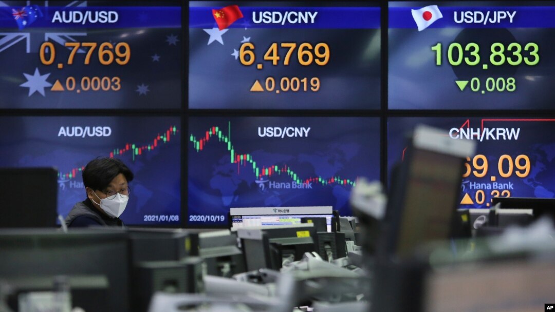 A currency trader watches monitors at the foreign exchange dealing room of the KEB Hana Bank headquarters in Seoul, South Korea, Jan. 8, 2021.