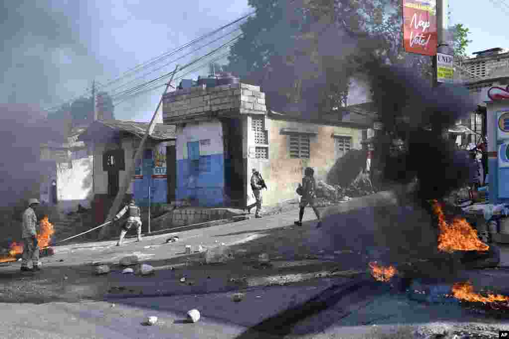 Tires burn after being set on fire by protesters upset with growing violence as police patrol and try to put out the flames and clear the road for vehicles in the Lalue neighborhood of Port-au-Prince, Haiti..