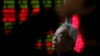 A man chats with other investors near an electronic board displaying stock prices at a brokerage house in Beijing, Jan. 5, 2016. 