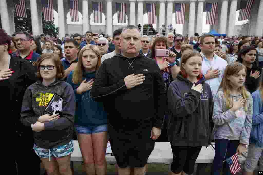 People gather to pay tribute to the more than 400,000 servicemen and women who lost their lives during the war, as "Taps" is played during a Memorial Day ceremony at Arlington National Cemetery, May 28, 2018, in Arlington, Virginia.