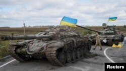Військовослужбовці ЗСУ поряд із захопленими російськими танками, Ізюм, Харківщина, 19 вересня 2022. REUTERS/Gleb Garanich