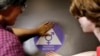 FILE - A new sticker is placed on the door at the ceremonial opening of a gender neutral bathroom at Nathan Hale high school in Seattle, May 17, 2016.