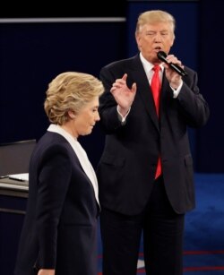 ​En esta fotografía de archivo del domingo 9 de octubre de 2016, la candidata presidencial demócrata Hillary Clinton pasa junto al candidato presidencial republicano Donald Trump durante el segundo debate presidencial en la Universidad de Washington.