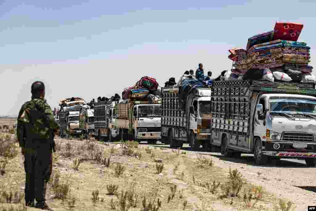 Syrian families sit in a truck after being released from the Kurdish-run Al-Hol camp, which holds relatives of suspected Islamic State (IS) group fighters, in the northeastern Syrian Hasakeh governorate.