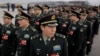 Delegates from China's People's Liberation Army (PLA) stand in line as they arrive at the Great Hall of the People to attend a session of National People's Congress in Beijing, March 4, 2016. China said Friday it will boost military spending by about 7 to 8 percent this year, the smallest increase in six years, reflecting slowing economic growth and a drawdown of 300,000 troops as Beijing seeks to build a more streamlined, modern military. 
