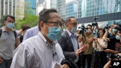 FILE - Various defendants including pro-democracy activists, Albert Ho, center, and Yeung Sum, right, arrive at a court in Hong Kong, May 17, 2021.