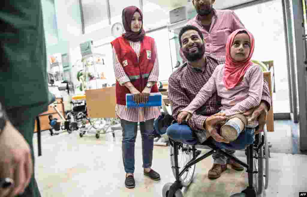 Eight-year-old Syrian girl Maya and her father, born without legs, arrive to an Istanbul clinic to get prosthetic legs after being evacuated from Syria. Earlier this month, Maya Merhi, 8, who was born with no legs due to a congenital condition, was moving around a Syrian refugee camp on artificial limbs made of plastic tubing and tin cans.But after pictures of her plight, including those taken by AFP in Syria were seen around the world, she was brought to Istanbul for treatment. And her life should be about to change."Maya will walk," said Dr Mehmet Zeki Culcu, the doctor treating her at an Istanbul hospital. 