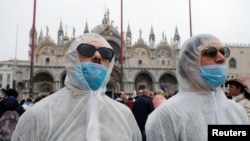Turisti nose zaštitne maske na karnevalu u Venciji, koji je skraćen za dva dana. 