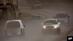 Vehicles drive on the main Black Rock road, covered with ash coming from the St. Vincent eruption of La Soufriere volcano, on the outskirts of Bridgetown, Barbados,April 11, 2021.