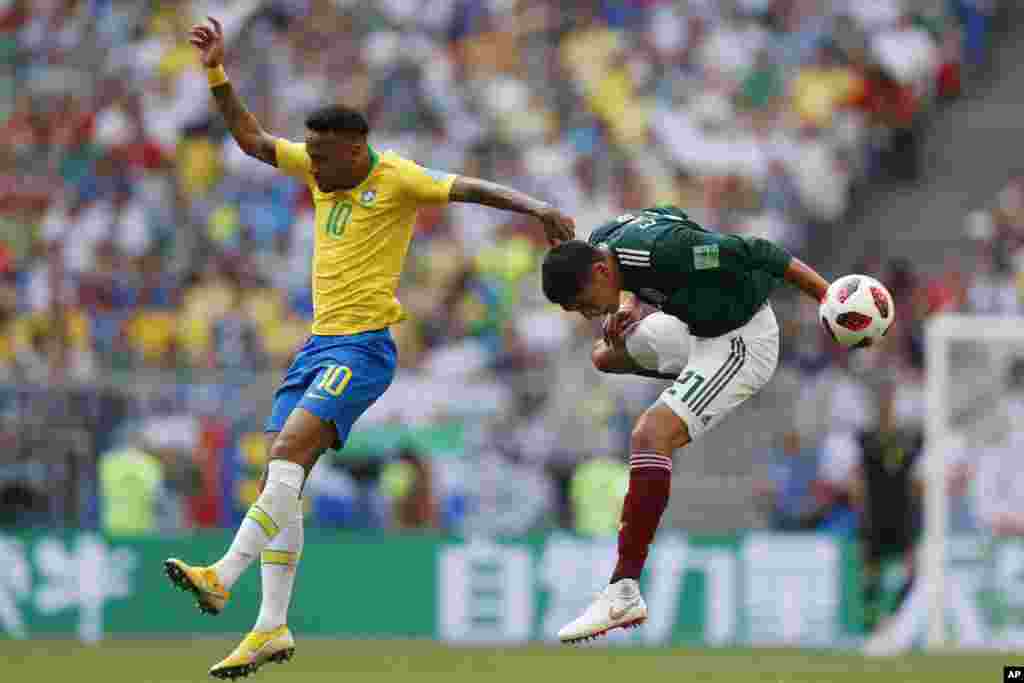 Brazil's Neymar, left, and Mexico's Edson Alvarez go for a header during their round of 16 match at the 2018 soccer World Cup in the Samara Arena, in Samara, Russia, July 2, 2018.