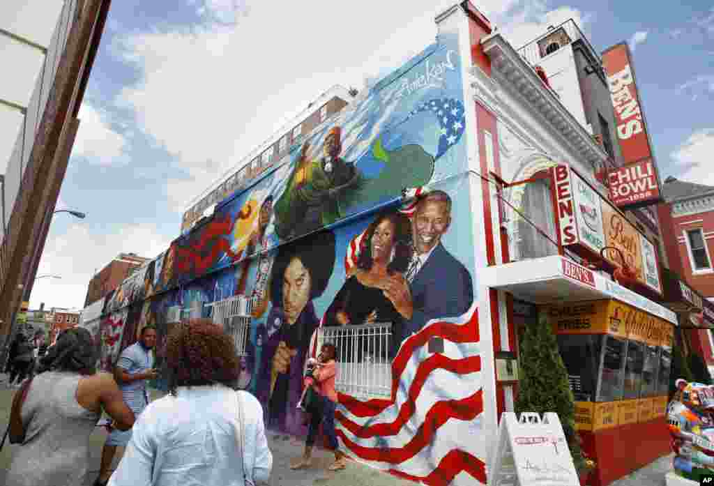 People take pictures of the new mural at Ben's Chili Bowl in Washington, D.C.