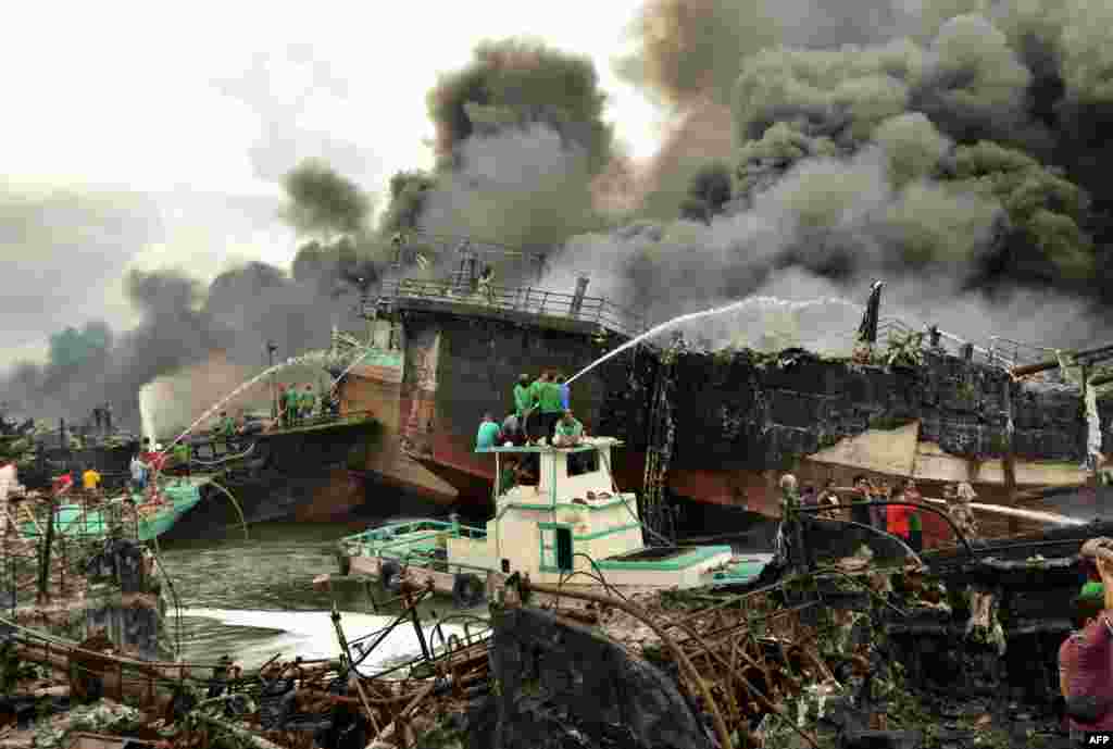 Indonesia firefighters try to extinguish a fire on fishing boats at Benoa harbour in Denpasar, on Indonesia's resort island of Bali.