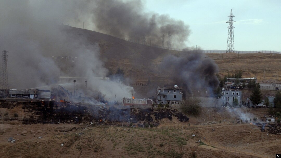 Smoke rises and fires still burn after Kurdish militants attacked a police checkpoint in Cizre, southeast Turkey, Aug. 26, 2016, with an explosives-laden truck, killing several police officers and wounding dozens more.