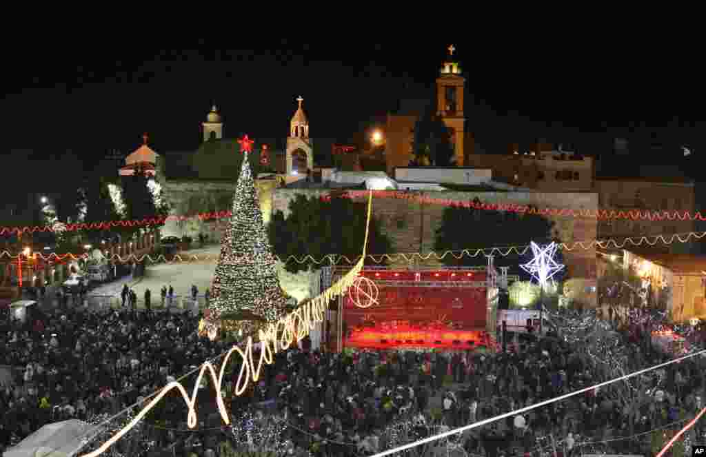 Christian worshippers and tourists celebrate at the Manger Square in front of the Church of the Nativity, in the West Bank town of Bethlehem, December 24, 2012.