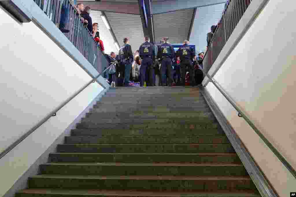 German federal police guard stairs while refugees wait for a new train after police stopped them for registration at the rail station in Freilassing, Germany, Sept. 15, 2015.