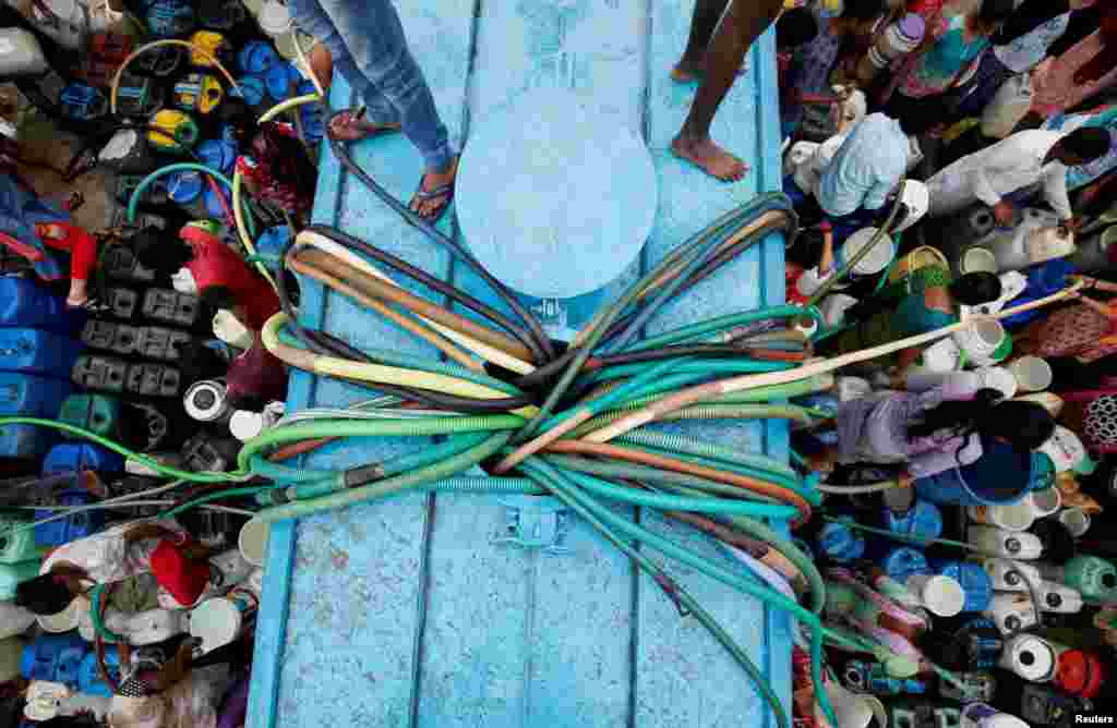 Residents fill their containers with drinking water from a municipal tanker in New Delhi, India.