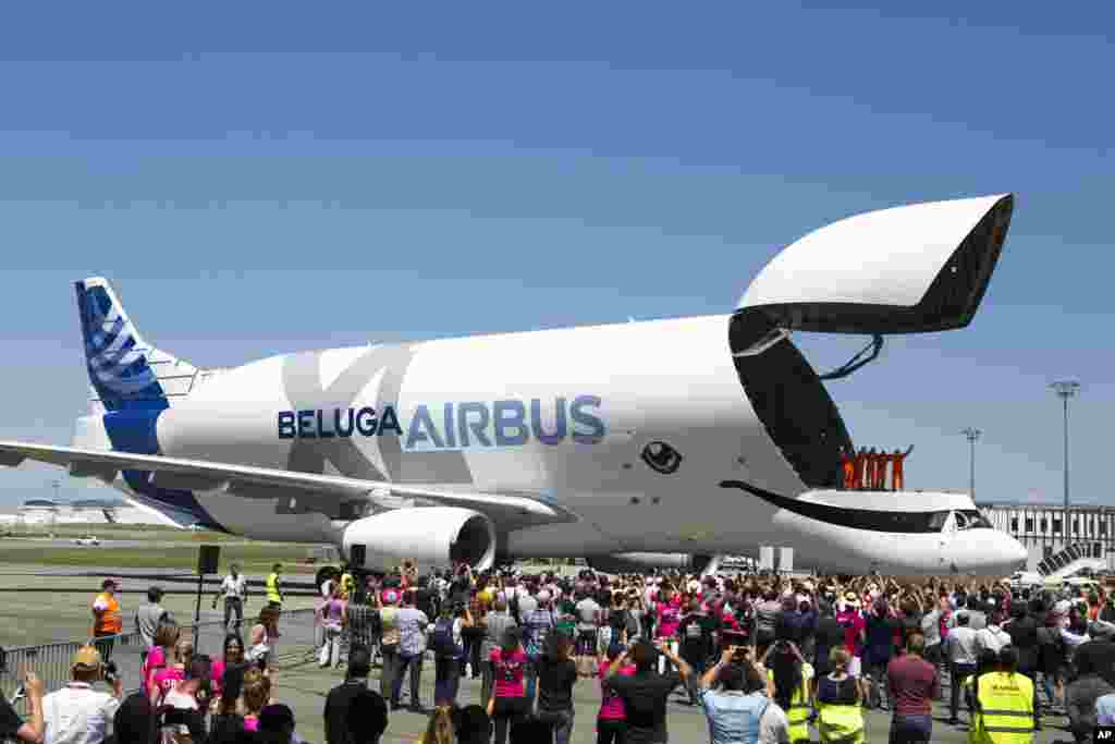 The engineers wave from the deck of the Airbus BelugaXL after successfully completing its first flight at Toulouse-Blagnac airport, in Toulouse, southern France.