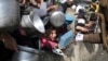 ARCHIVO - Palestinos hacen fila para recibir comida durante la ofensiva aérea y terrestre israelí en curso en Rafah, Gaza, el 9 de enero de 2024.