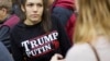FILE - A woman wears a shirt reading "Trump Putin '16" while waiting for Republican presidential candidate Donald Trump to speak at a campaign event at Plymouth State University in Plymouth, N.H., Feb. 7, 2016.