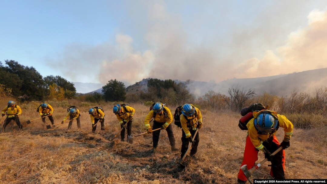 A hotshot crew works on a fireline while the Bond Fire burns in Silverado, Calif., on Dec. 3, 2020. 