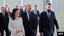 阿拉伯叙利亚通讯社发布的照片显示法国外长巴罗(中)和德国外长贝尔伯克(左)与叙利亚新的统治者沙拉在会晤前走在一起。(2025年1月3日)