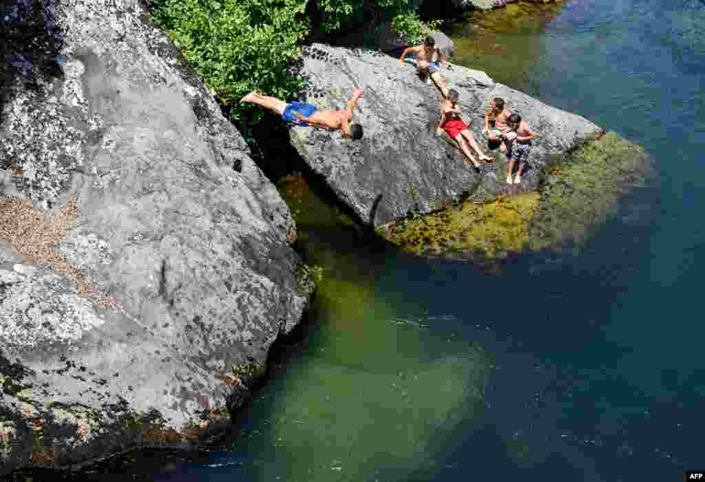 A young man dives in the river Treska near Skopje, Macedonia, as temperatures reached 37° C (98.6° F).