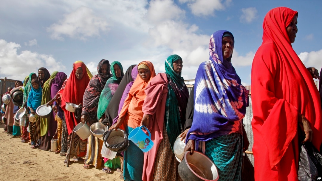 Women who fled drought queue to receive food distributed by local volunteers at a camp for displaced persons in the Daynile neighborhood on the outskirts of Mogadishu, in Somalia, May 18, 2019.