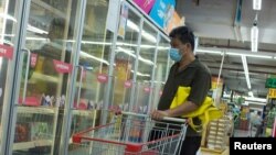 一名男子戴口罩在超市选购冷冻食品。（2020年8月13日）