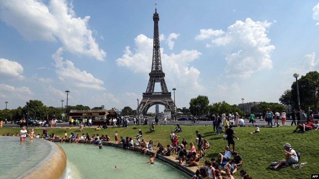 People cool themselves at the Fontaine du Trocadero in front of The Eiffel Tower in Paris 