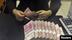 中国招商银行安徽合肥的一家支行的员工数算人民币百元钞票。（2015年4月20日）